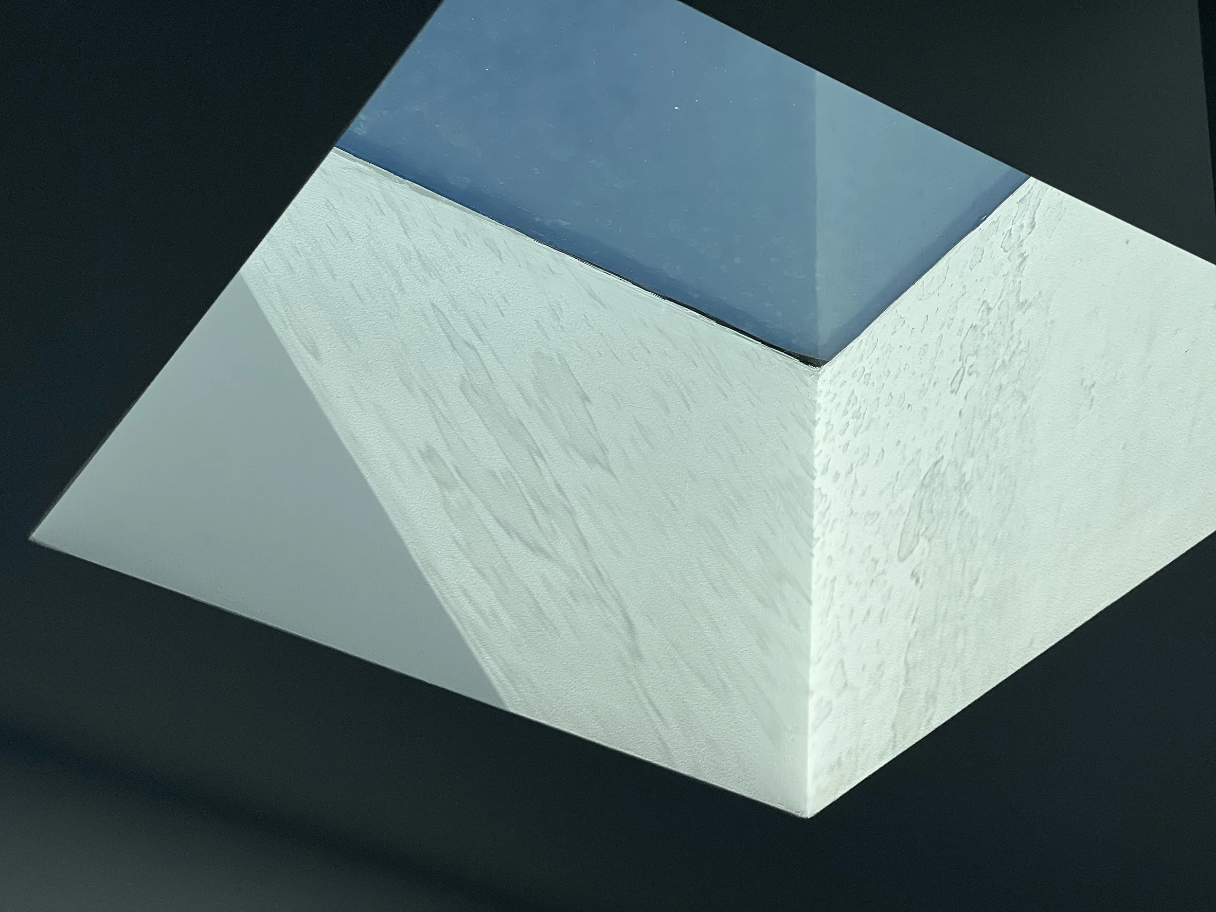 Close-up of a geometric architectural structure with black, white, and blue surfaces, creating a striking modern design.