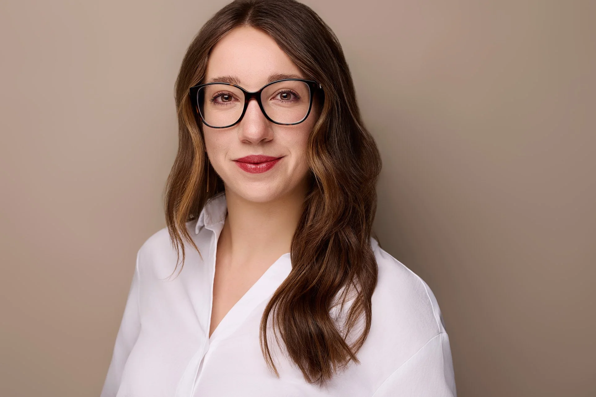 Ein LinkedIn Profilbild von einer  jungen Frau mit Brille