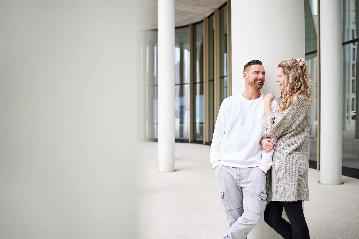 Ein paar Fotos von einem Pärchen an einer weißen Säule gelehnt