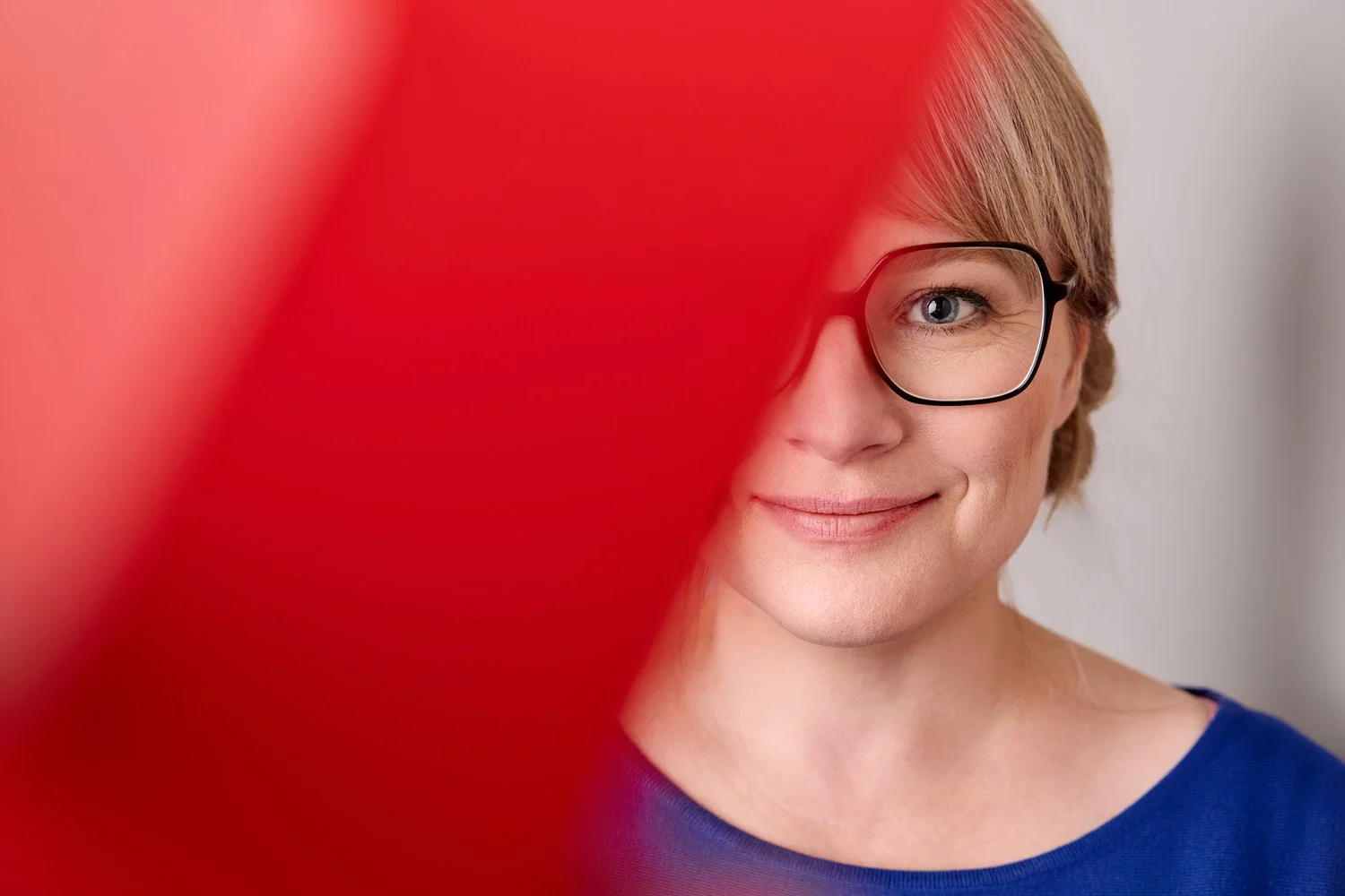 Ein Business Portrait von einer blonden Frau mit Brille