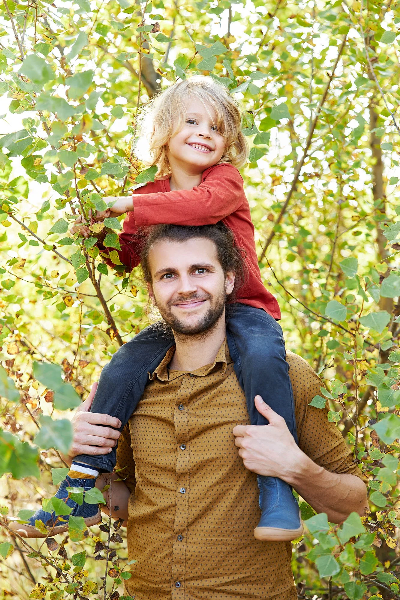 Ein Papa hat seinen Sohn auf den Schultern