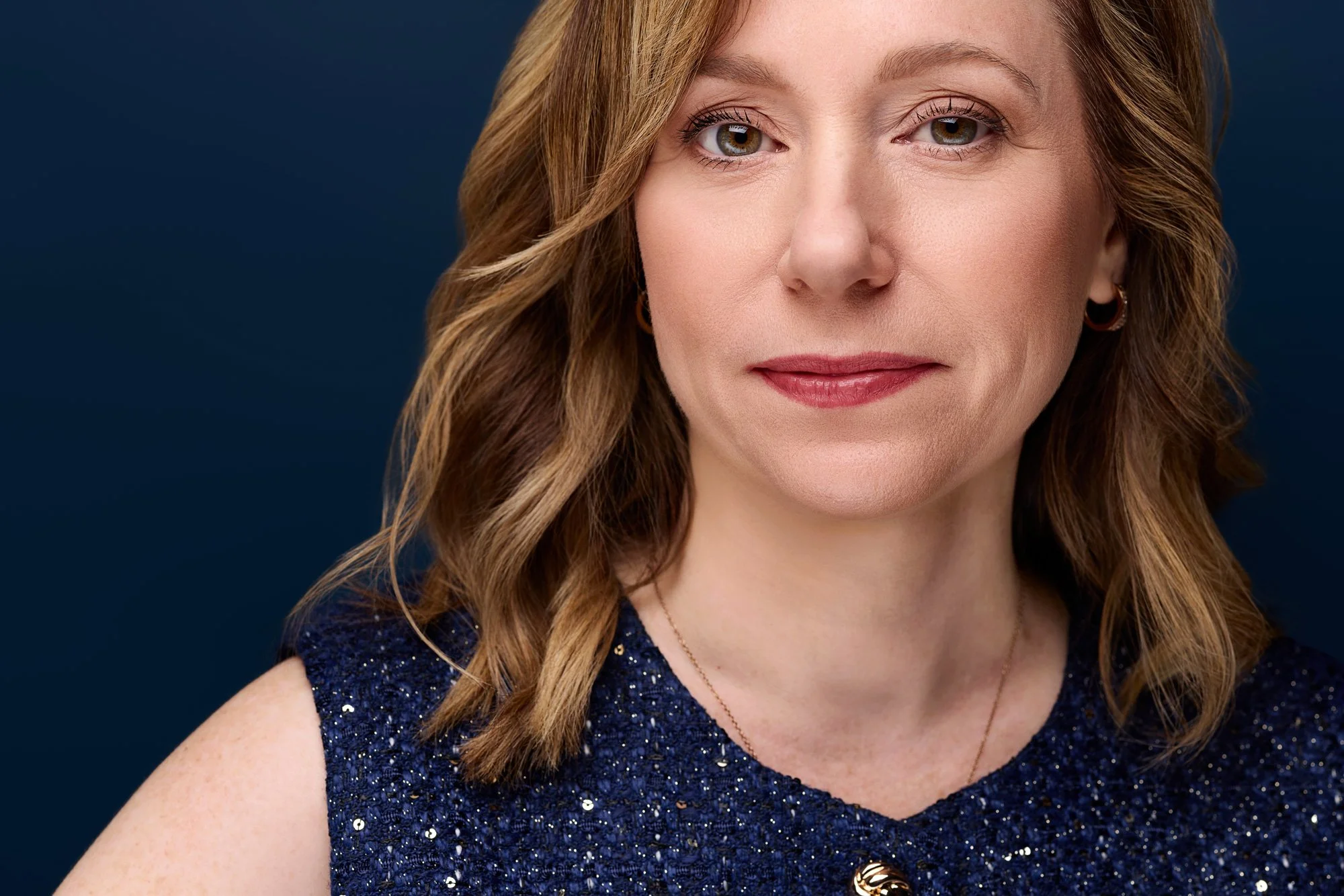 Porträt einer blonden Frau vor blauen Hintergrund