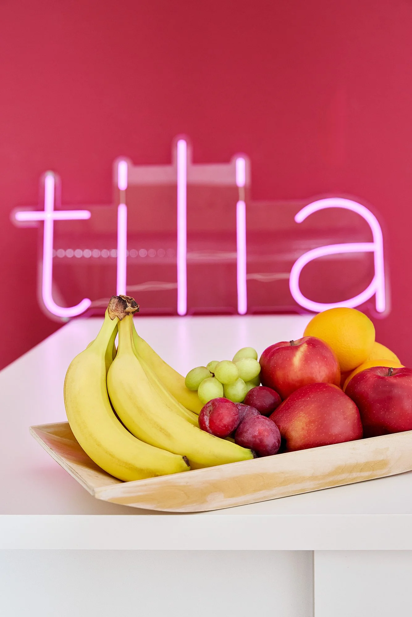 Ein Obstkorb vor einer Neonleuchtschrift