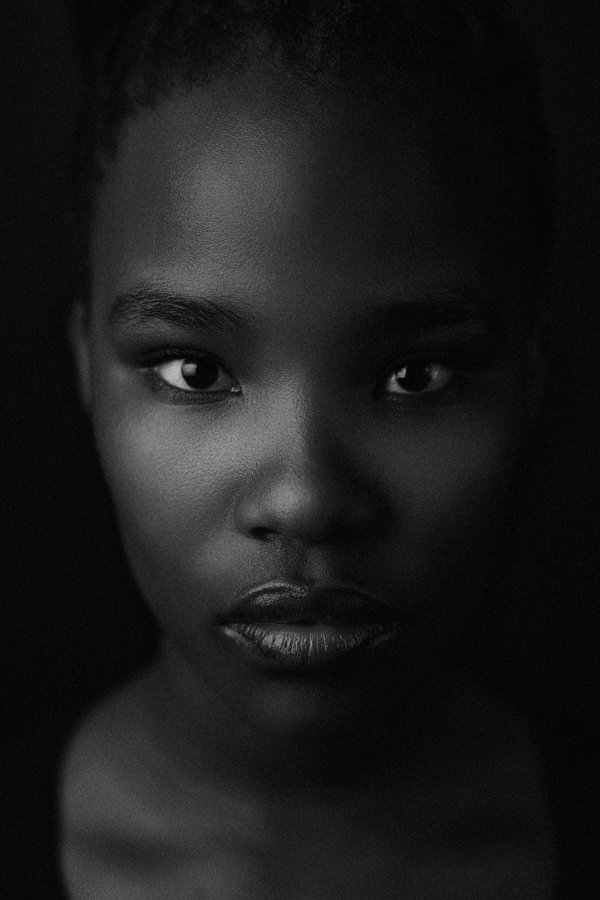 Ein Portrait vor einer jungen Frau in schwarz-weiß mit Blick in die Kamera