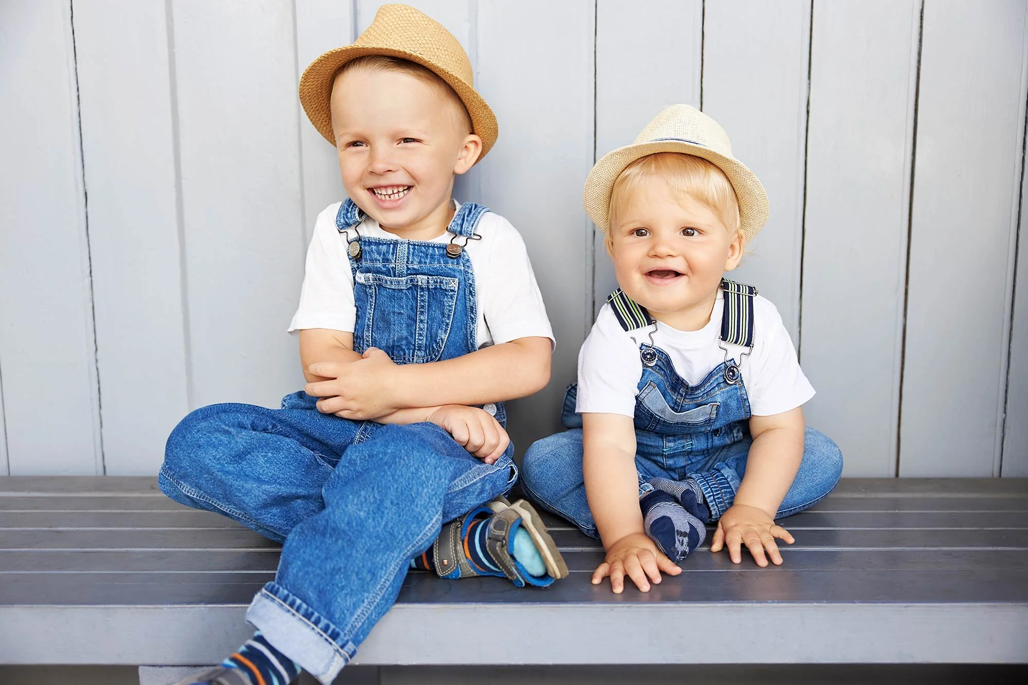 Zwei kleine Jungs sitzen nebeneinander auf einer Bank