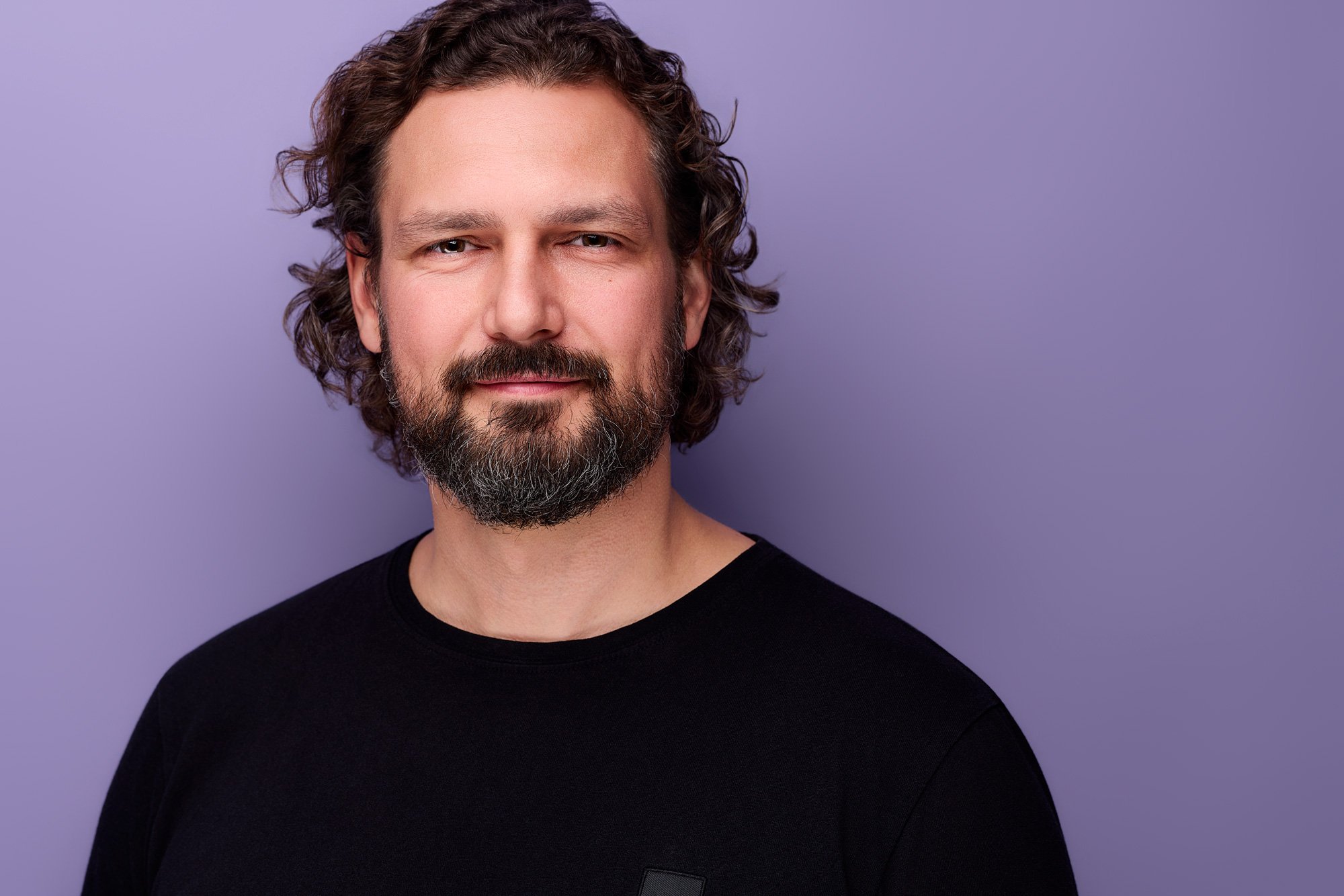 Ein Mann mit dunklem Shirt macht Bewerbungsfotos in Leipzig