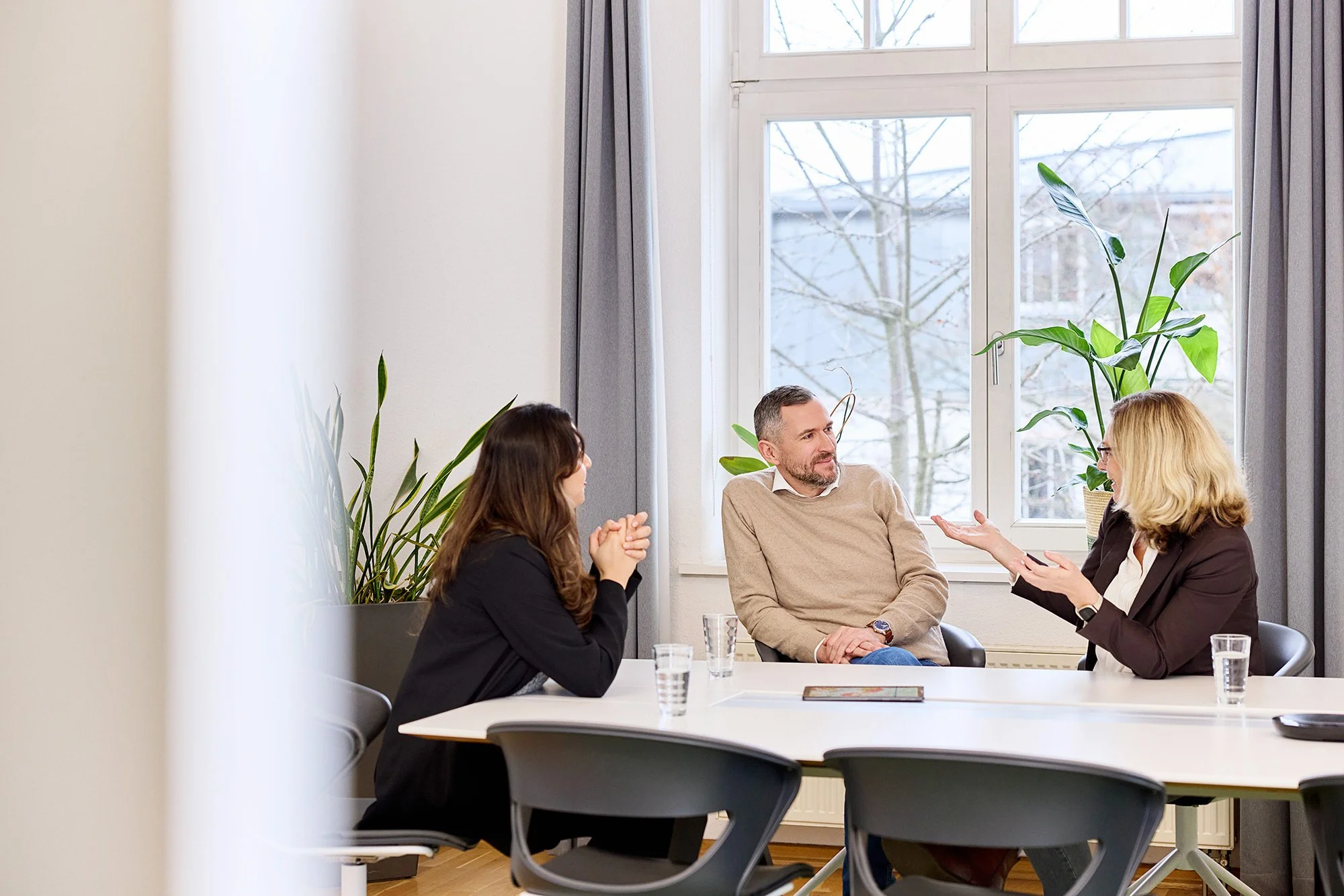 Drei Mitarbeiter führen ein Gespräch im Büro