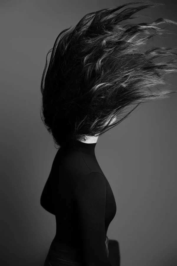 Eine Frau wirft ihren Kopf nach hinten in den Nacken, um ihre Haare zu schwingen