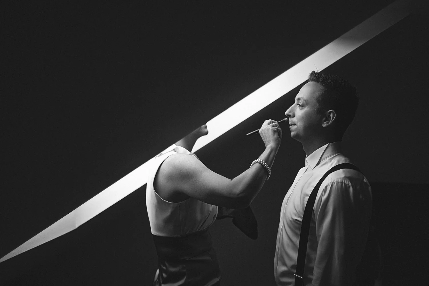 Ein Mann wird vor einer Dachluke geschminkt