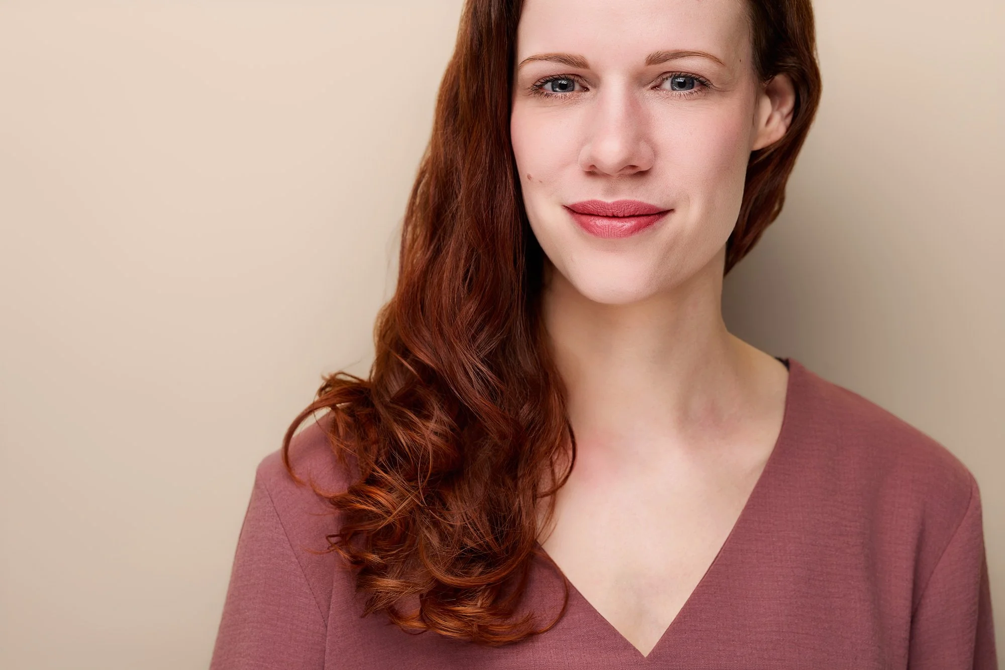 Eine Frau lächelt in einem Fotostudio in die Kamera