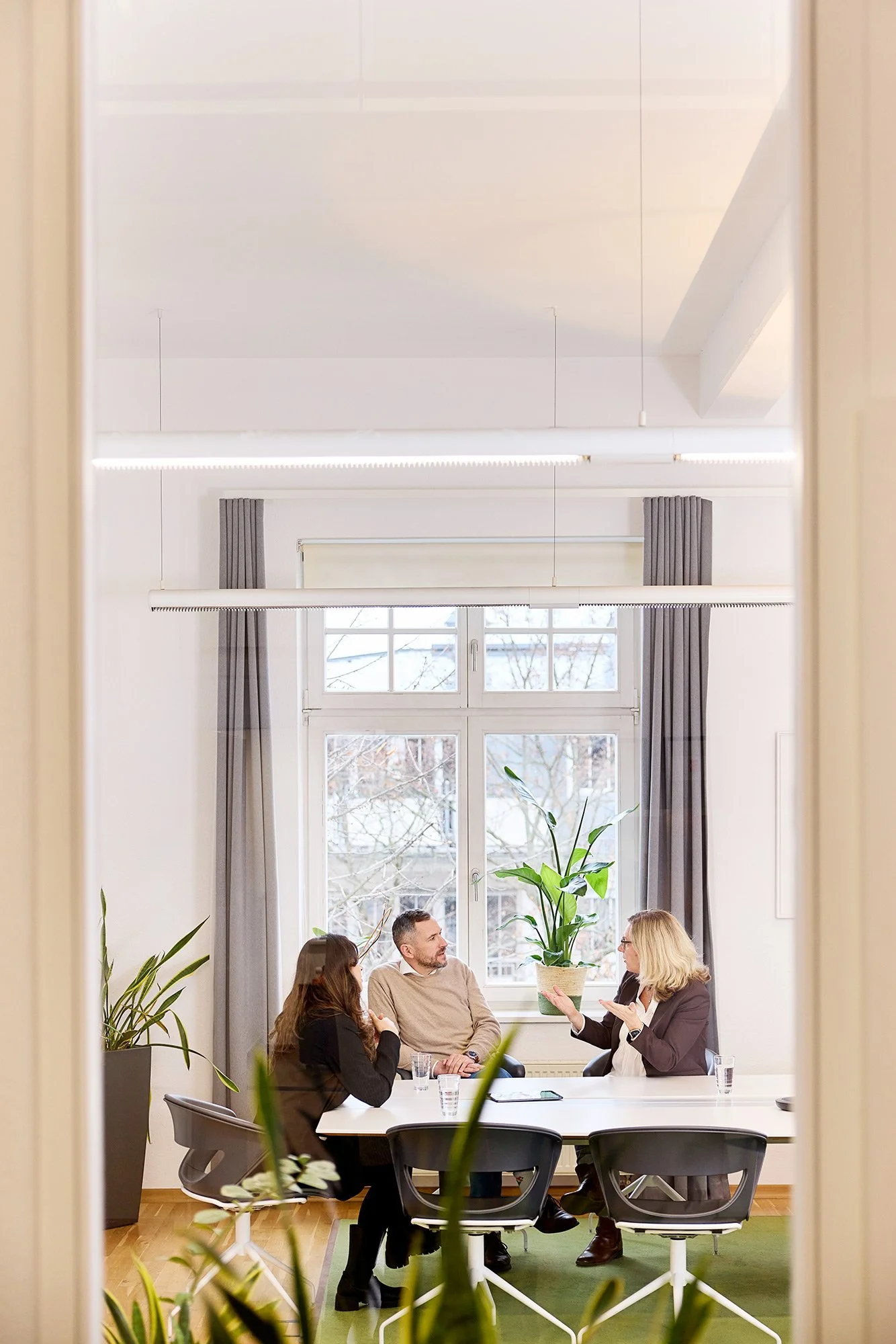 Eine kleine Gruppe von Personen in einer klassischen Beratungssituation im Büro