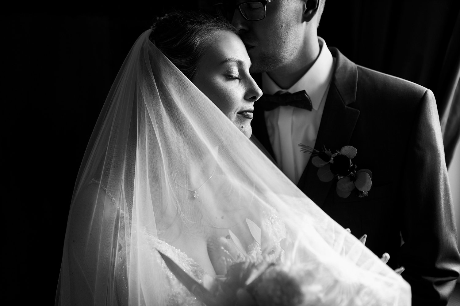 Eine Braut mit Schneier in einer schwarz-weiß Aufnahme mit geschlossenen Augen