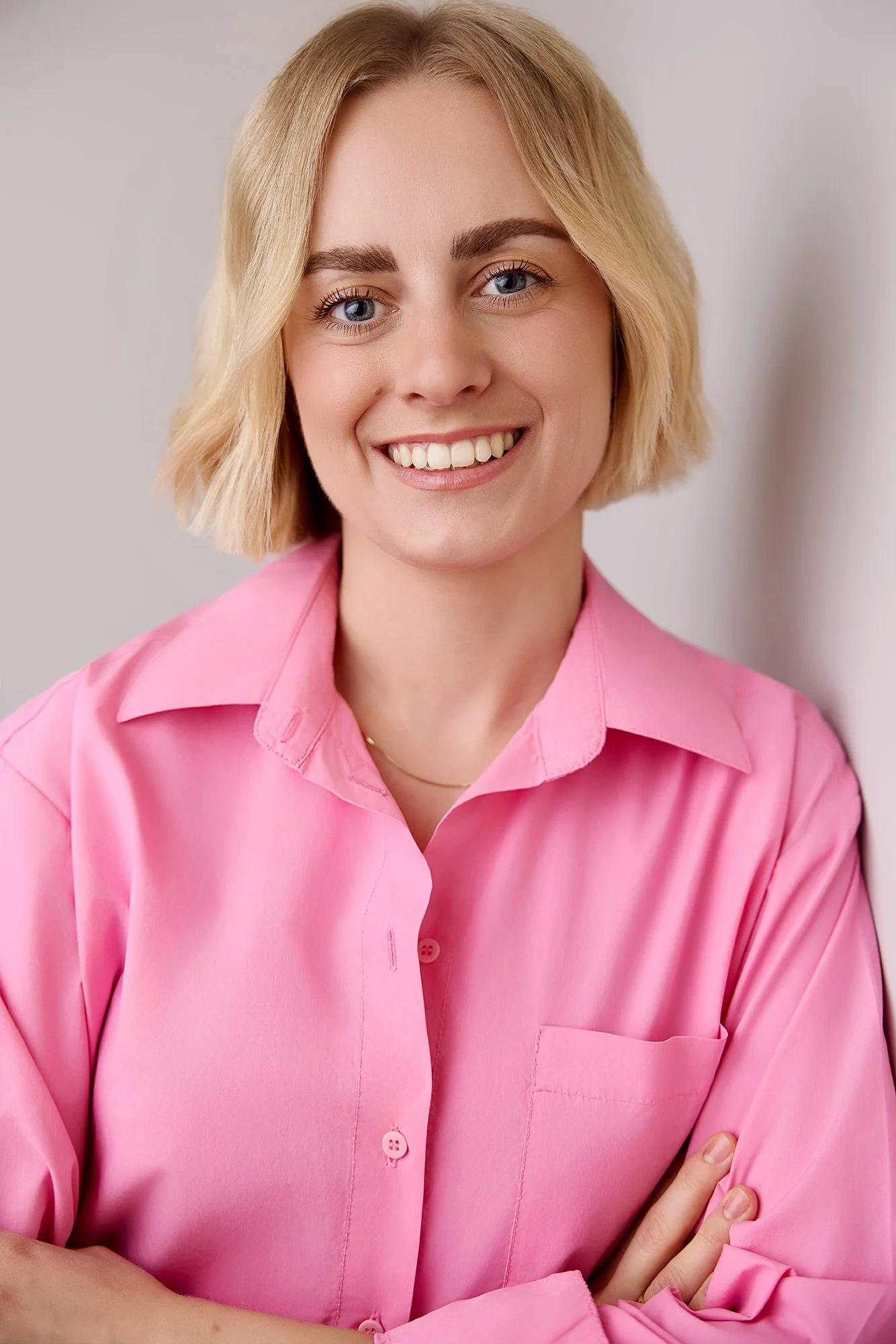 Ein Businessfoto einer Frau mit rosafarbenen Shirt