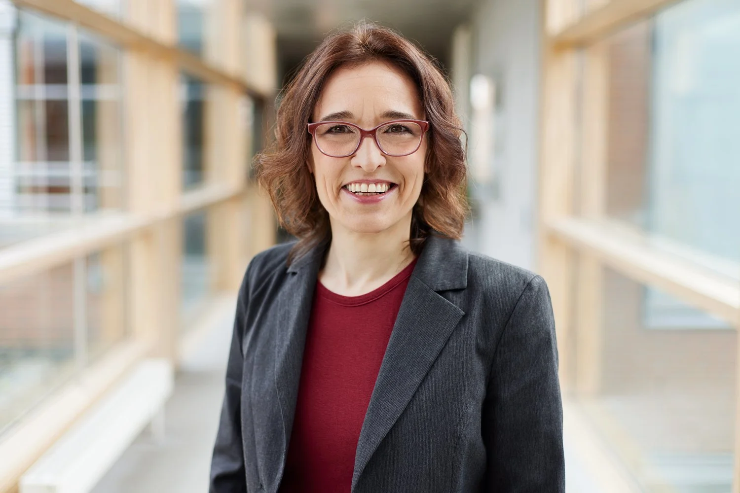 Eine Frau mit roter Brille lächelt für ihr Business Foto die Kamera