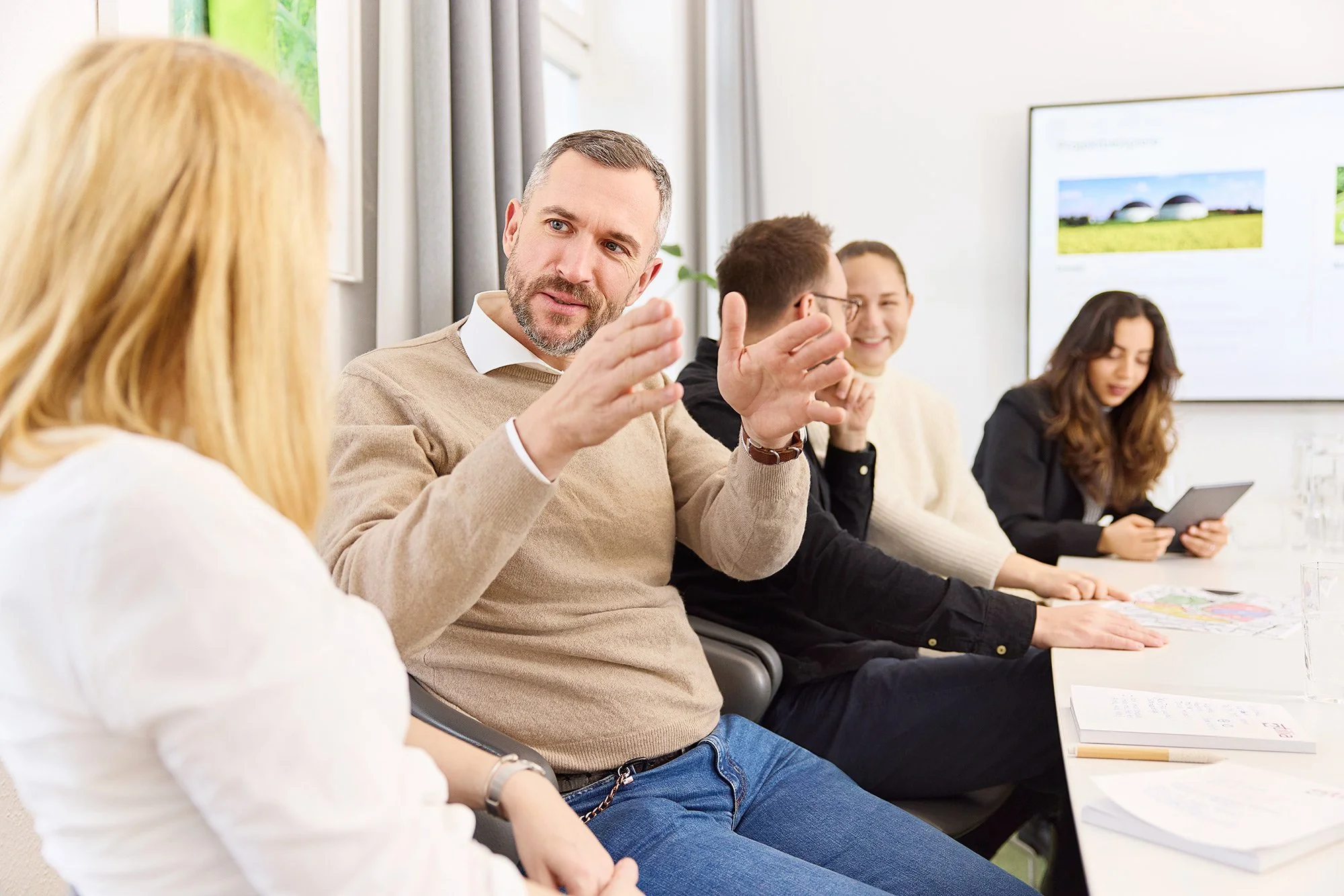 Ein Mitarbeiter erklärt seiner Kollegin etwas während einer Beratung Situation und gestikuliert mit den Händen