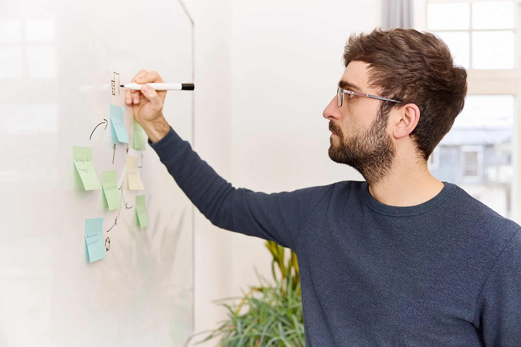 Ein Mann schreibt etwas an ein Whiteboard