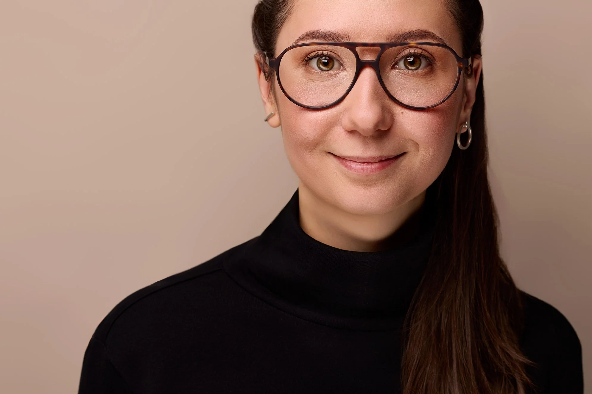 Eine Frau mit markanter Brille schaut in die Kamera