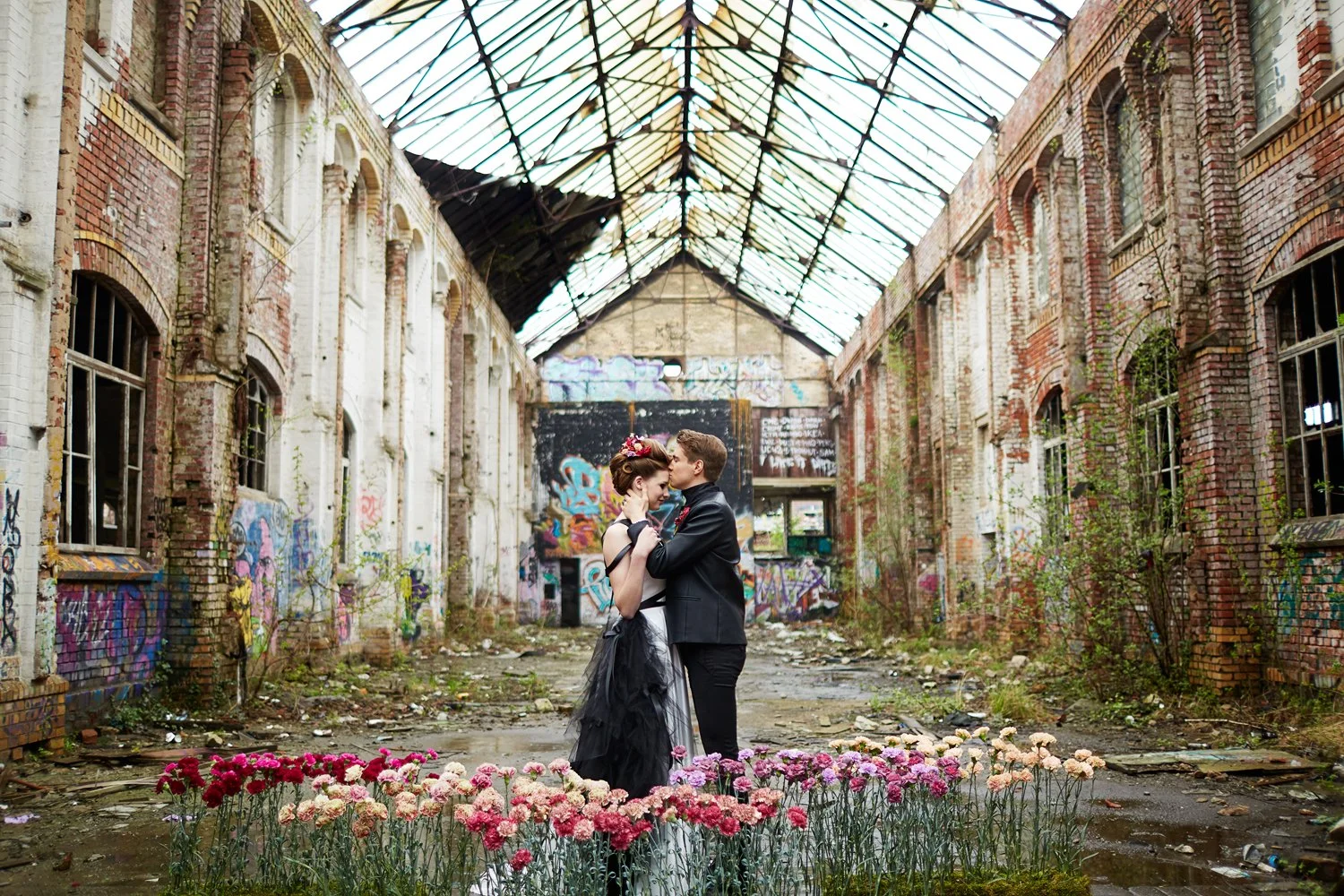 Ein Brautpaar stellt sich auch am Bauch in einer Ruine in Leipzig gegenüber