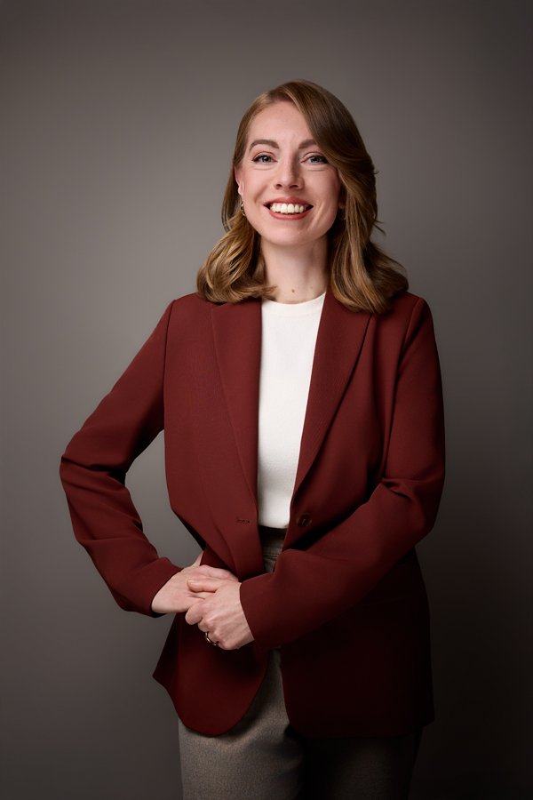 Eine Frau mit rotem Jacket pausiert für ihr Business Foto