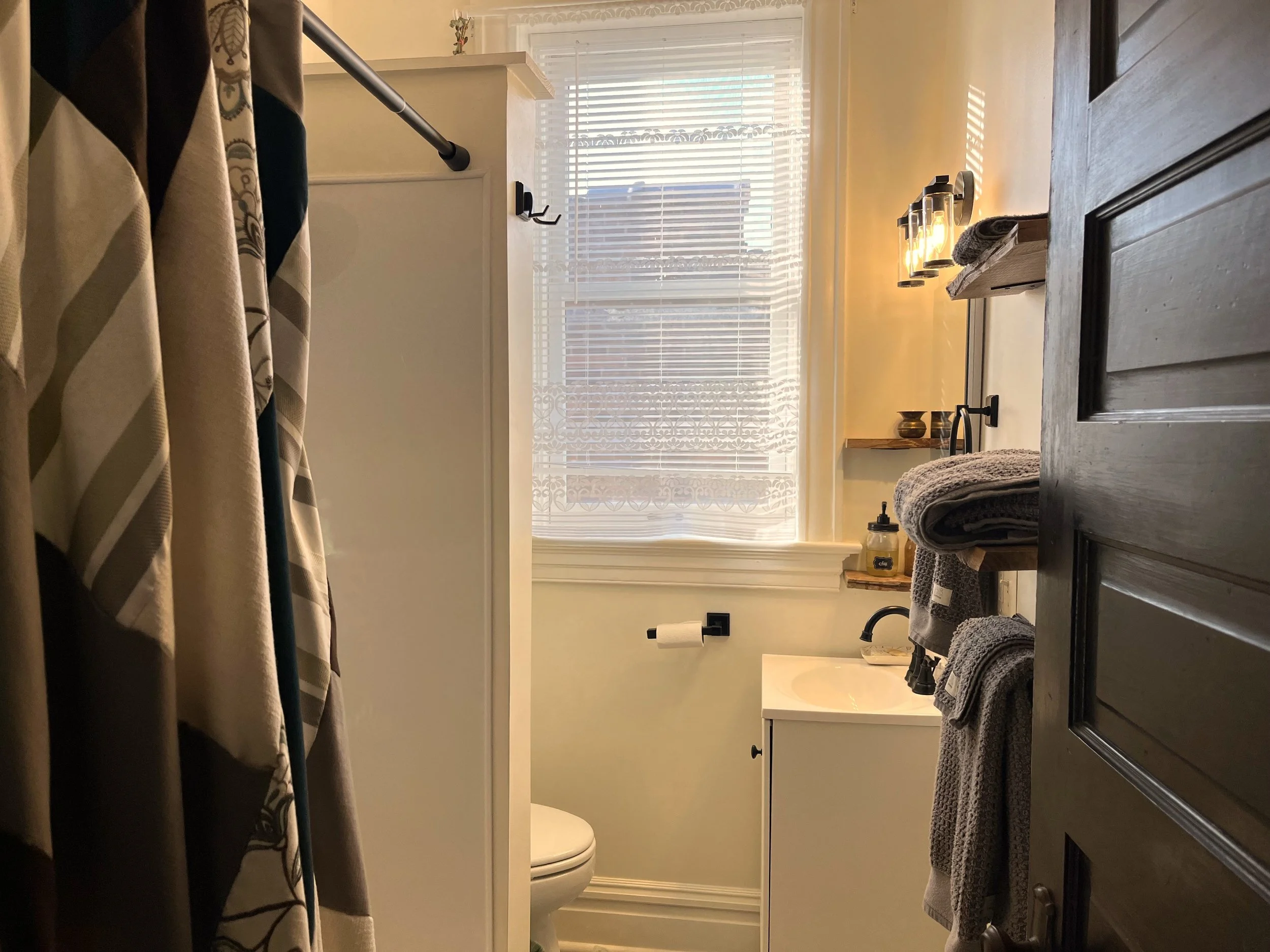 In the bathroom, we replaced the shower wall, the vanity and faucet, light fixtures, and added shelving. 