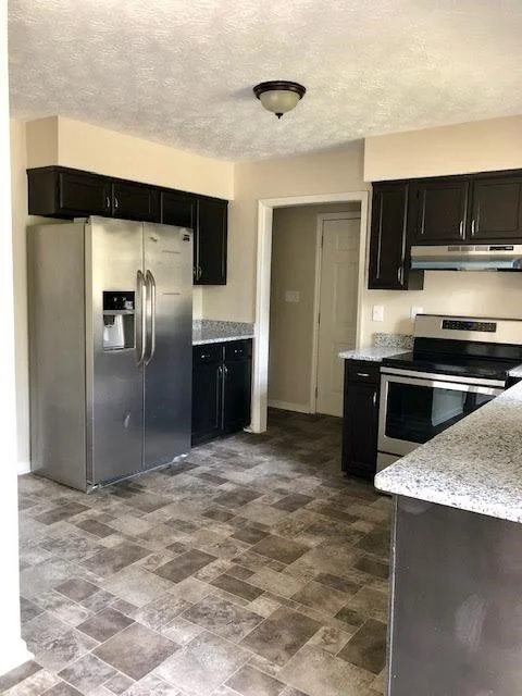 New appliances and flooring. The kitchen cabinets were in great condition so we painted them a dark brown and added granite counters.