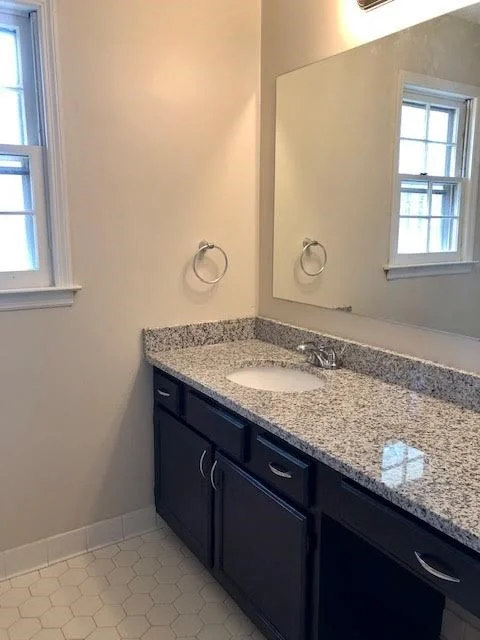 After. The original hexagon tile floor was kept and cleaned up.  The vanity was repainted and new hardware, counter, sink and faucet installed.  