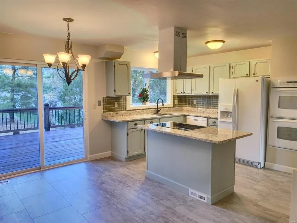 After.  We took out the peninsula and added an island.  The cabinets had new hardware and pulls installed, painted, and reconfigured. The original kitchen backsplash was in good shape, so we cleaned it up and drew inspiration for the colors of the ki