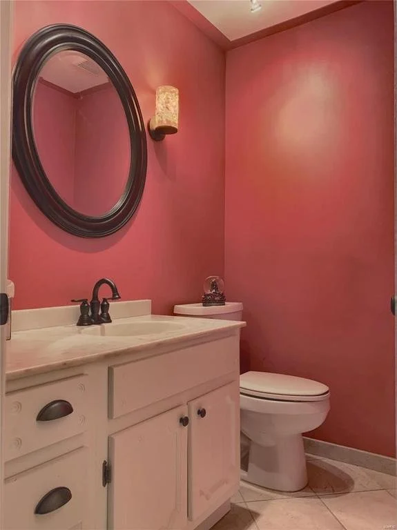 Half bath after.  I had started this project with my Grandma about 18 years prior so the coral wall color, mirror, and light fixtures had to stay.  We kept the original vanity but painted it and added new pulls to give an updated look.