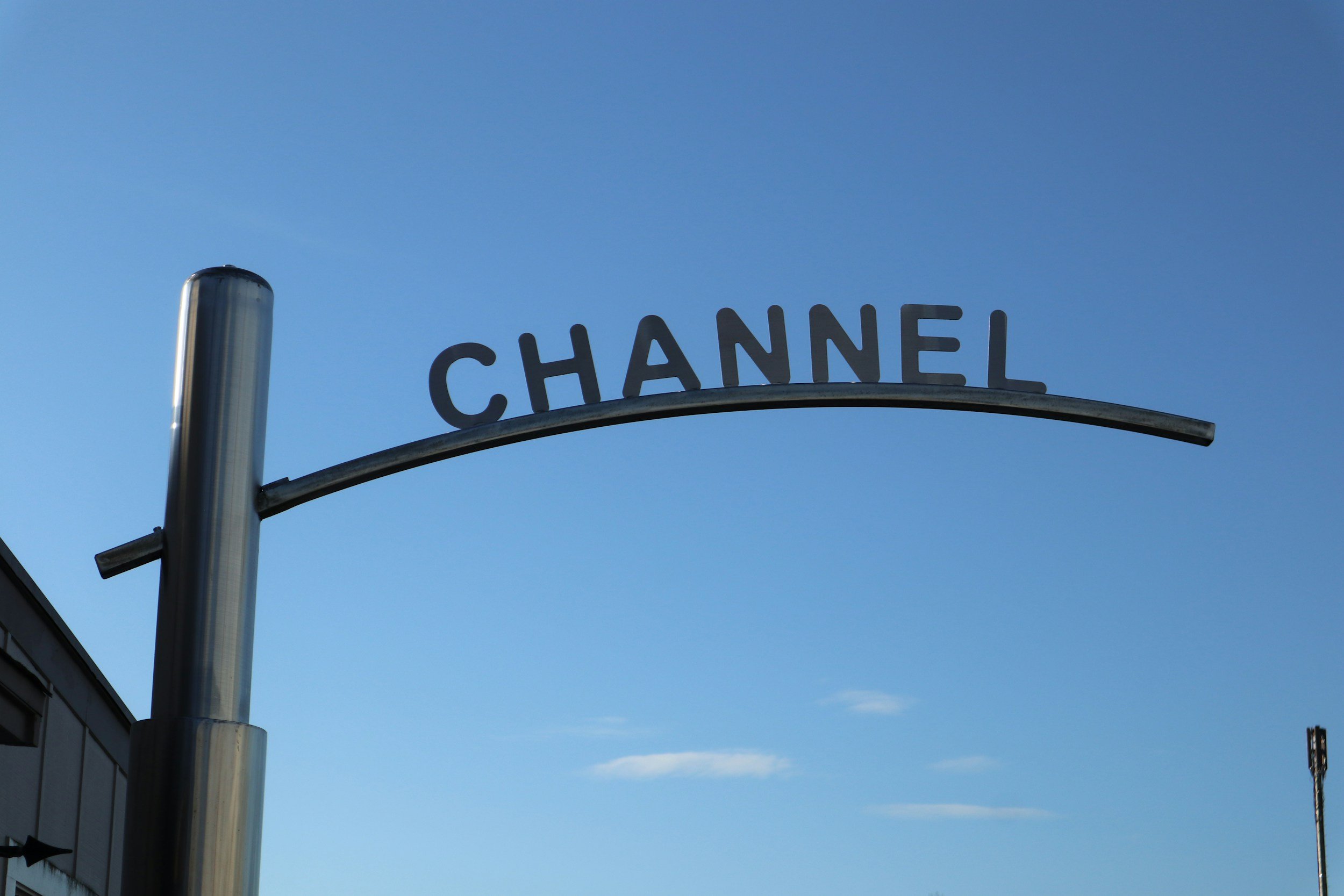 Street sign with the word "CHANNEL" on a clear blue sky background.