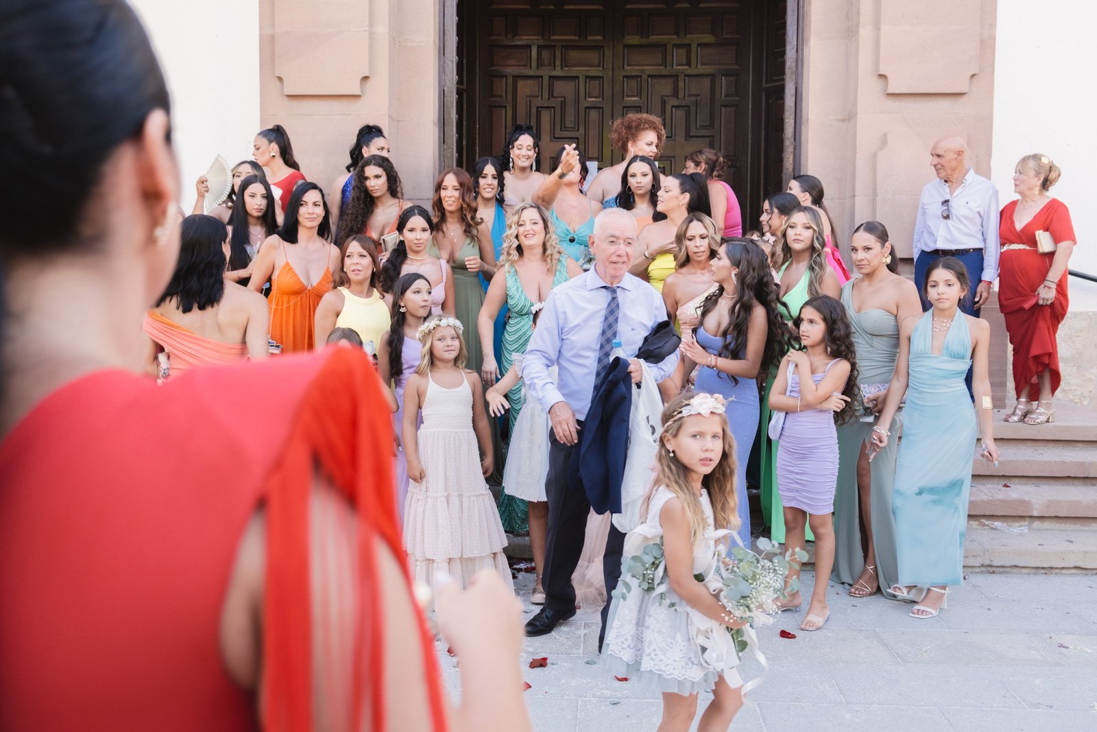 familia de mujeres reuniendose frente a una iglesia de malaga para el retrato grupa
