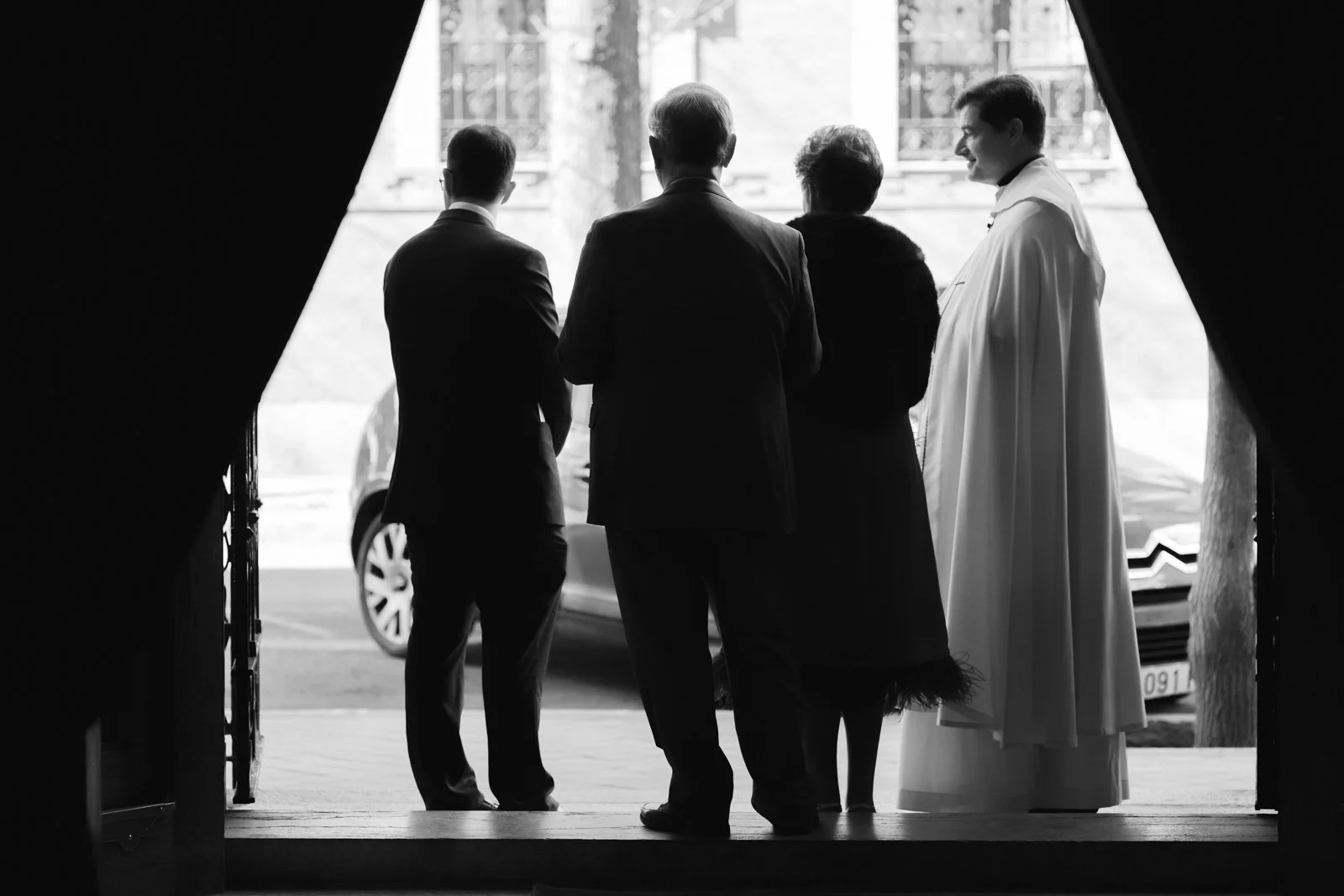 contraluz a la entrada de la iglesia de personas esperando
