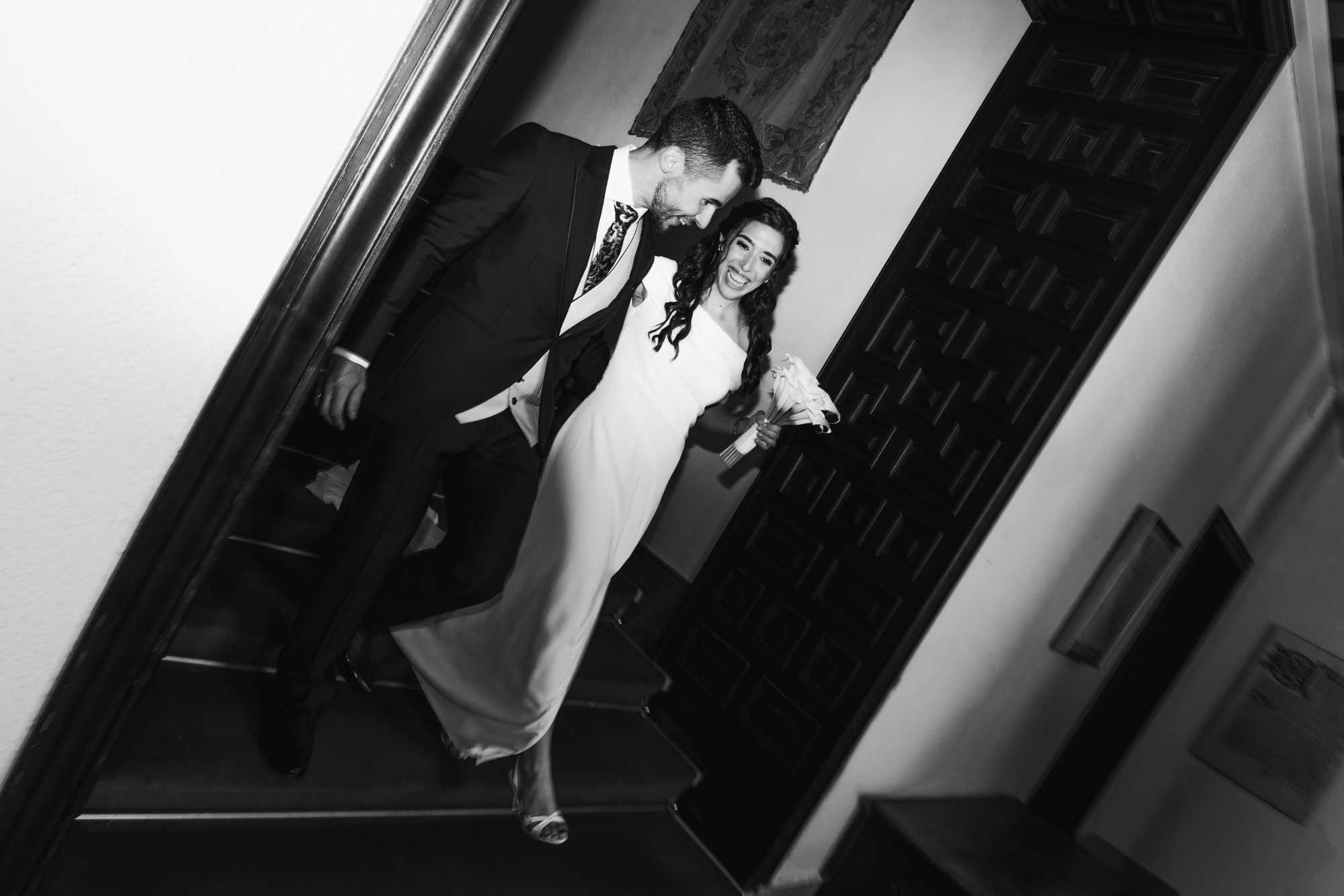 Retrato de boda editorial con flash, pareja elegante bajando escaleras, vestido de novia Teresa Tegar, zapatos Manolo Blahnik, traje novio Paco Araque