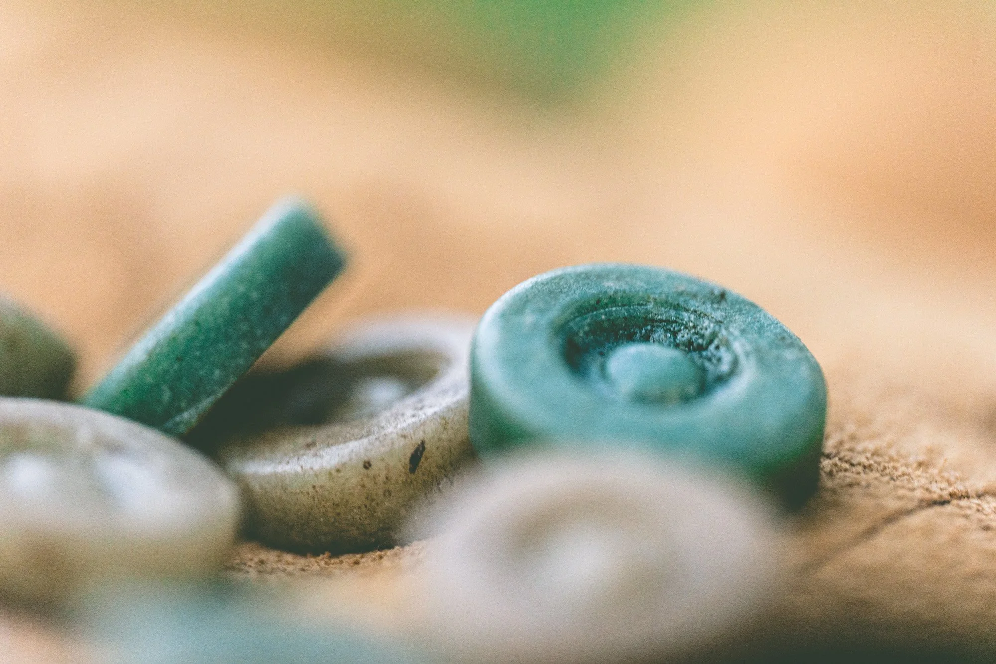 Primer plano de varias fichas o piezas circulares de color verde y gris sobre una superficie.