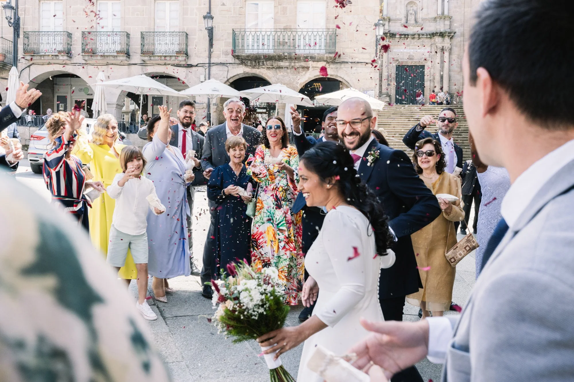 Salida de los novios recibidos entre arroz y pétalos en una plaza