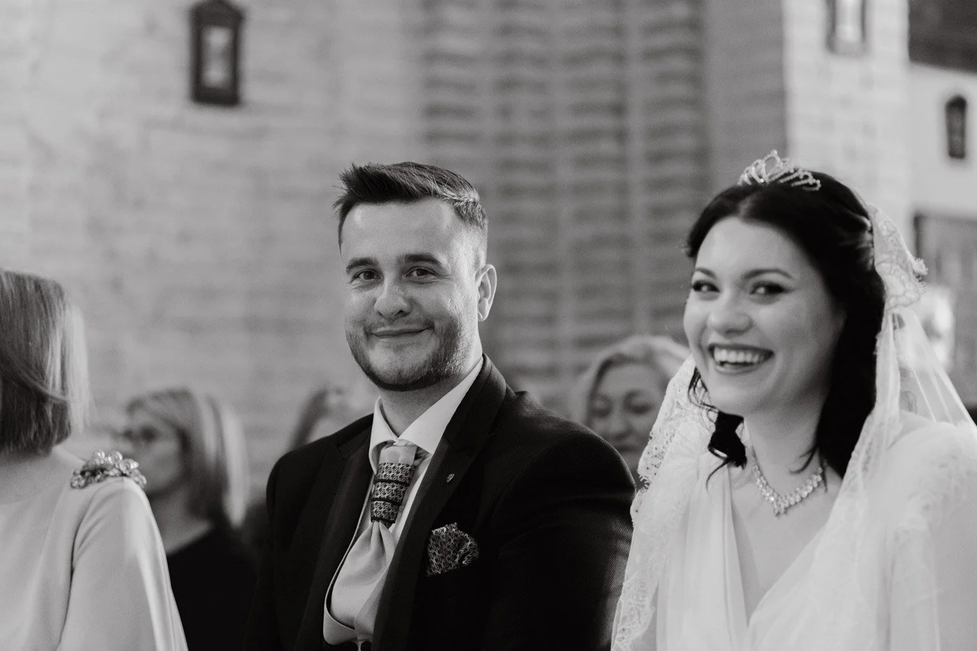novios mirando a cámara y riendo en la iglesia