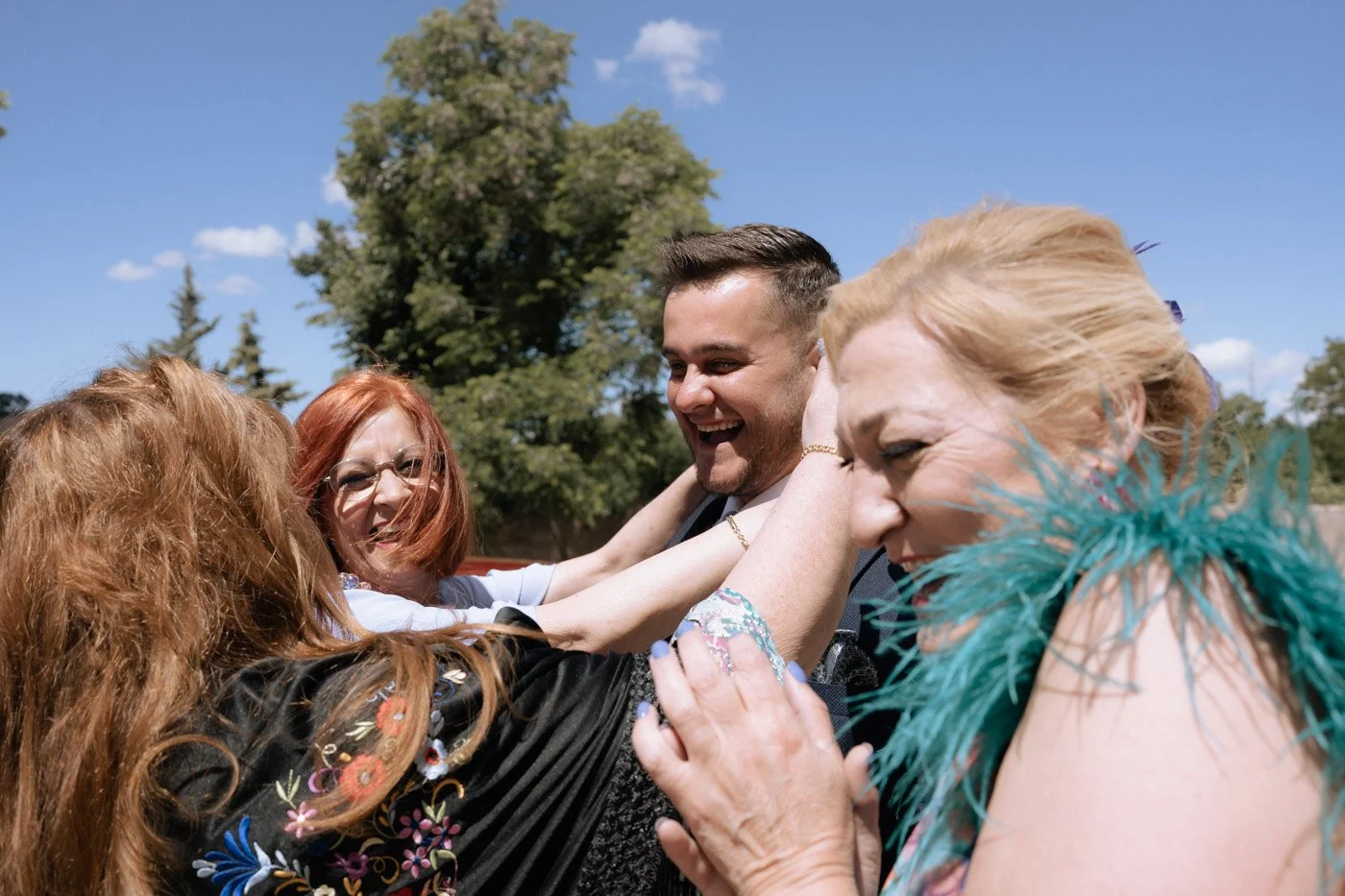 Familia abrazando al novio en su boda