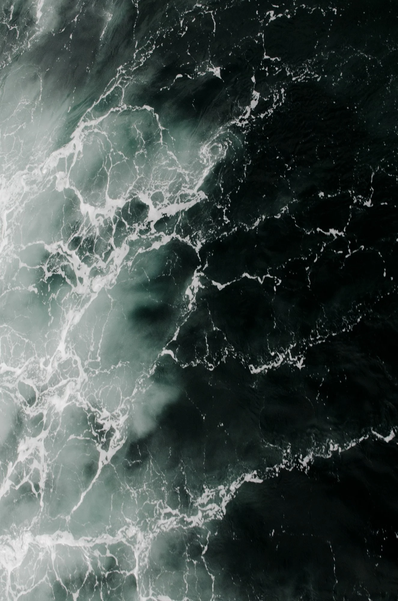 Olas del océano con espuma blanca sobre agua oscura