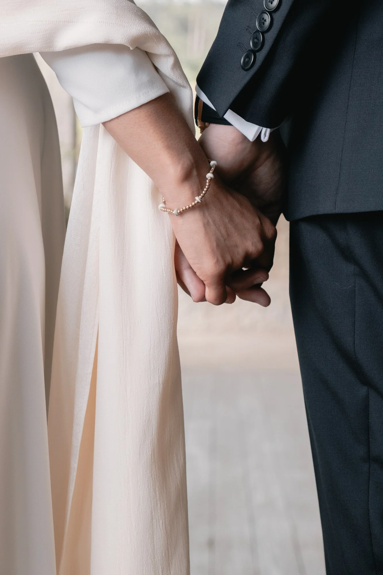 Detalle de manos de pareja con trajes de boda