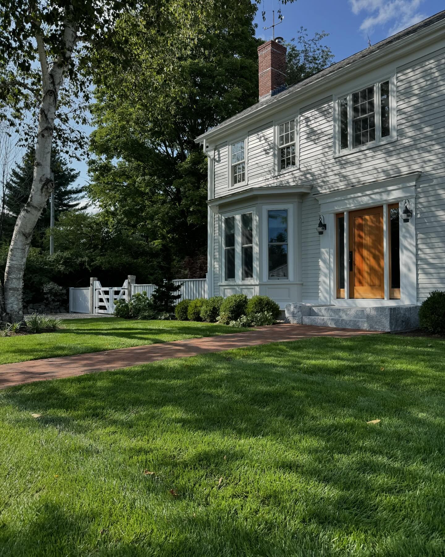A classic brick walkway and vibrant greenery guide you to this beautifully renovated farmhouse.
