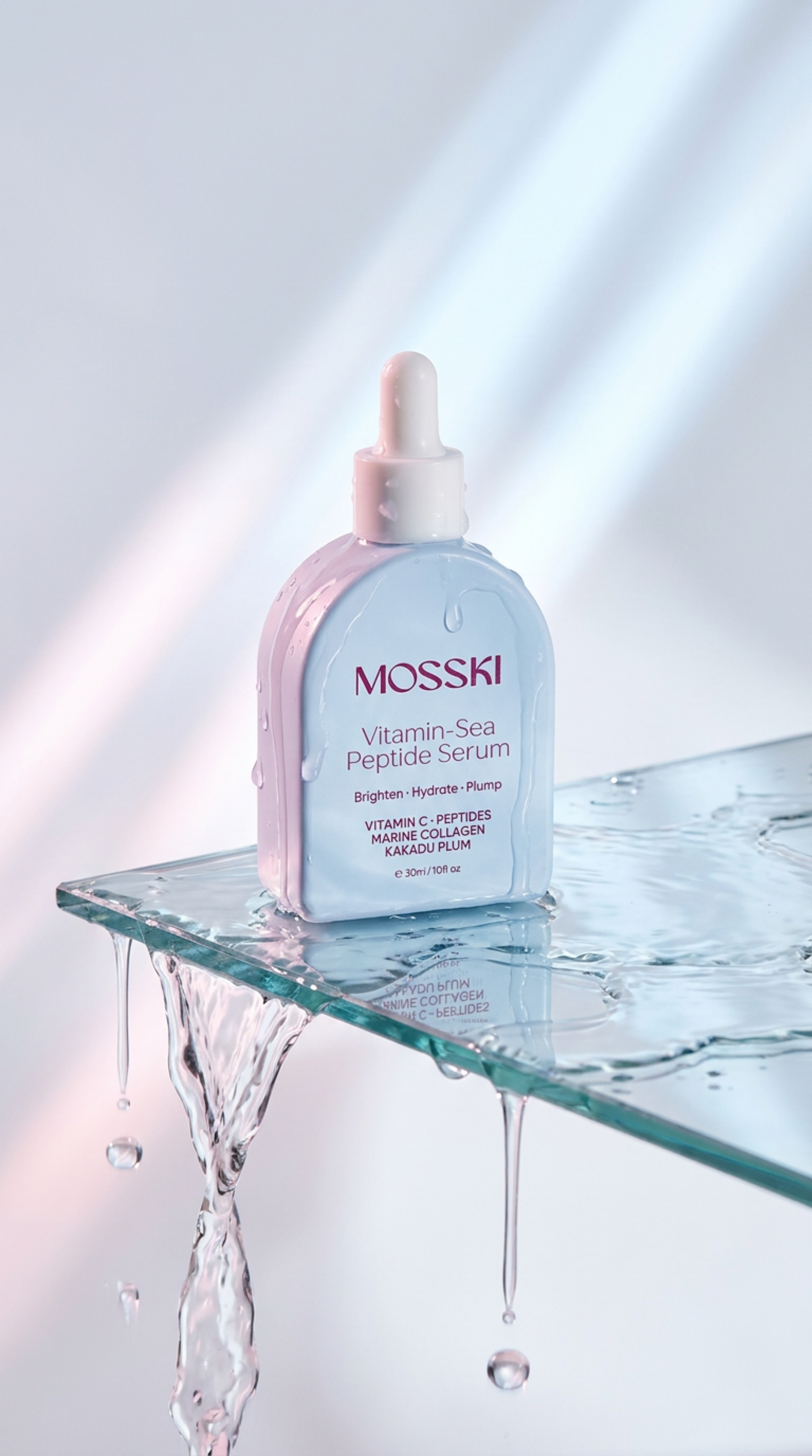 Bottle of Mosski Vitamin-Sea Peptide Serum with water droplets, placed on a glass surface with water splashing.