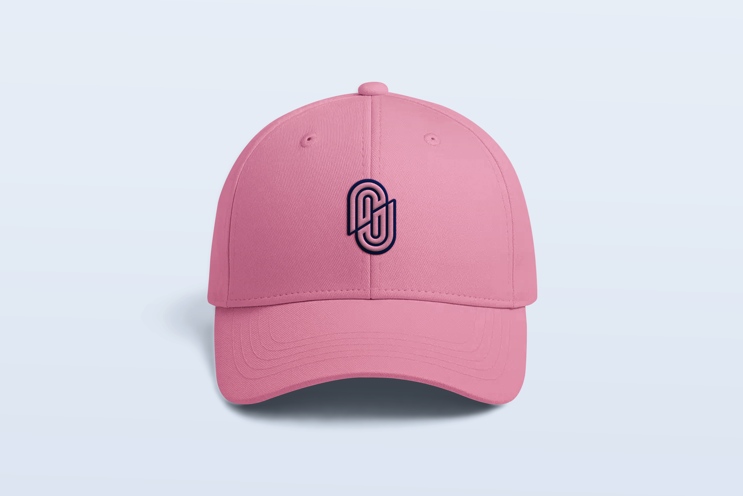 Pink baseball cap with a black embroidered logo on the front, placed against a light blue background.