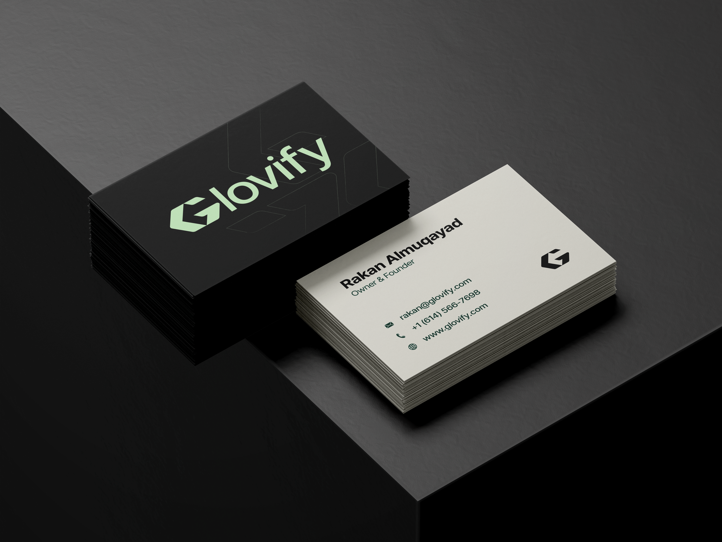 A stack of black business cards with the logo and name 'Glovify' in green, next to a white business card with contact information for Rakan Almugadd.