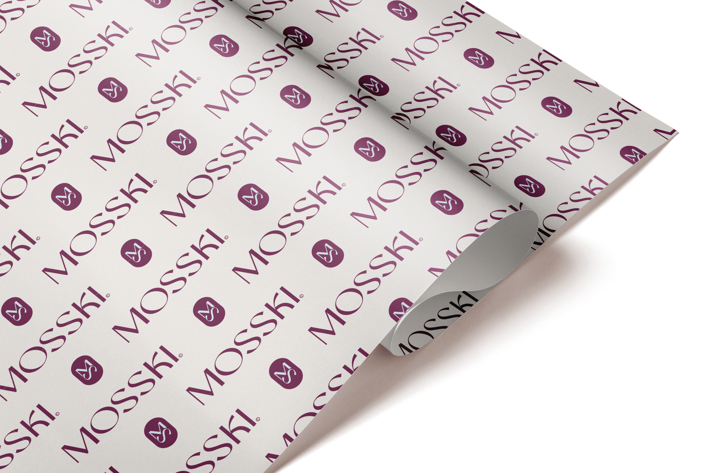 A sheet of paper with the MAC Cosmetics logo and branding in purple, partially rolled on a brown surface.