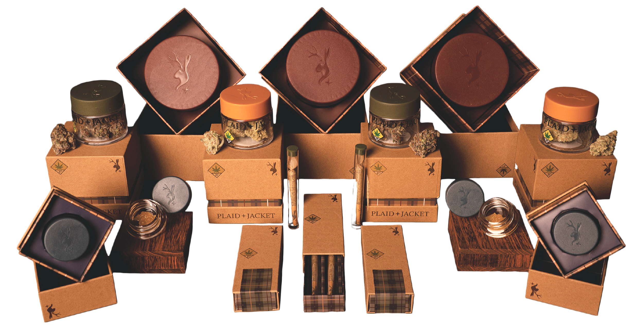 A collection of cannabis products, including jars of cannabis buds, pre-rolled joints, and grinders, arranged on a wooden surface with branded boxes and packaging, for "Plaid + Jacket."