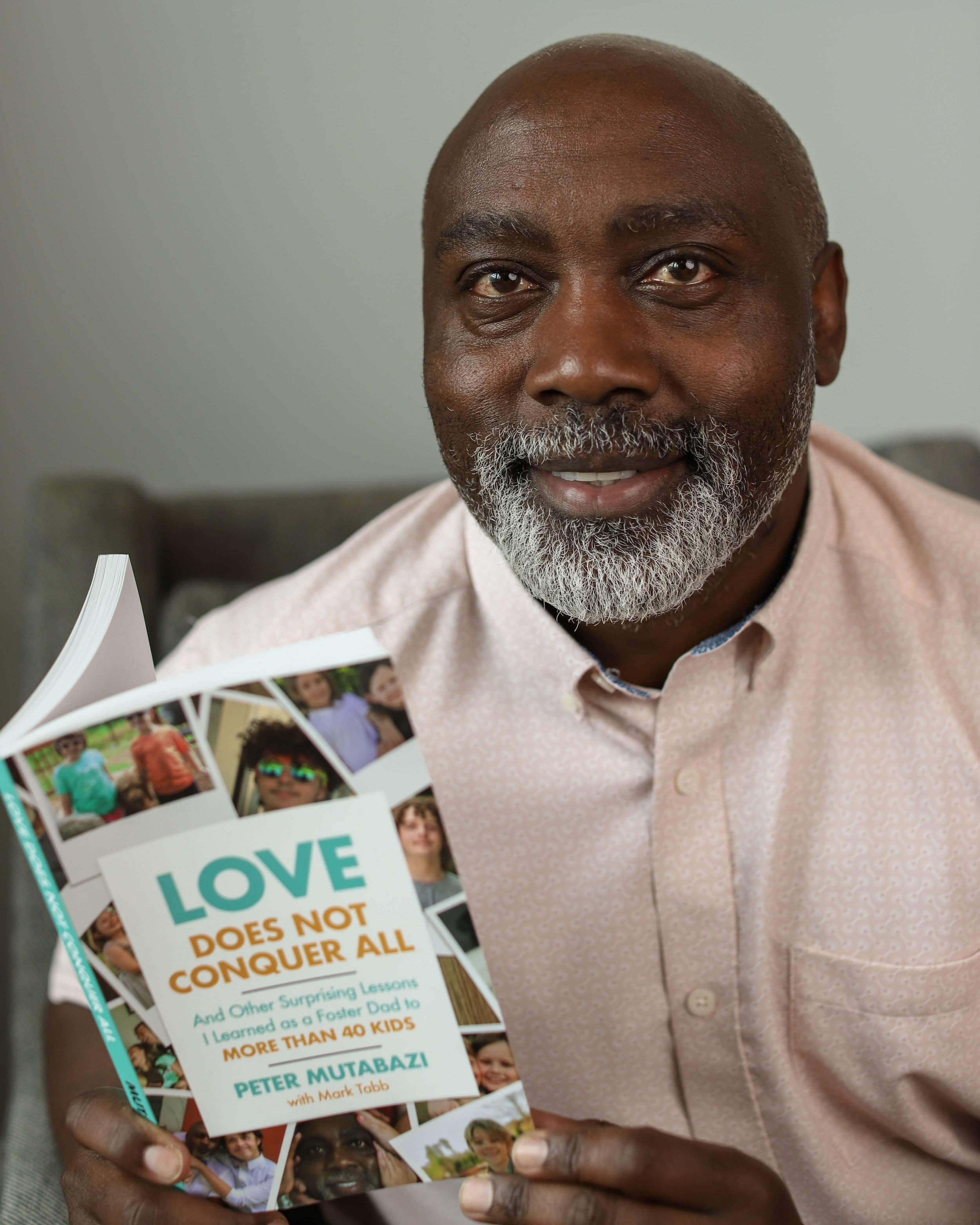 Peter Mutabazi Headshot with Book.jpeg