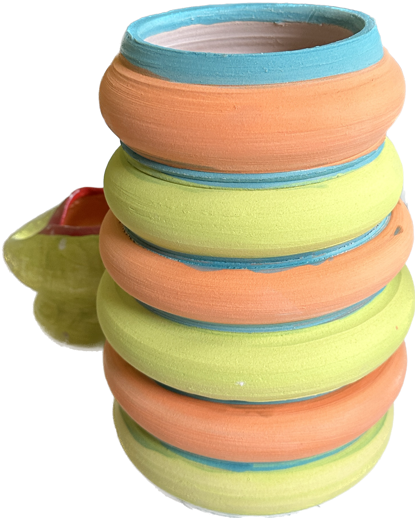 Stack of colorful, smooth, intertwined rings with alternating orange and green patterns and blue edges; background has a partial view of a yellow object. No identifiable objects or text present.
