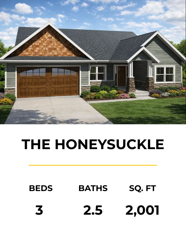 Front view of a modern single-family house with gray siding, a gable roof, and a wooden garage door, surrounded by landscaped lawn and bushes.