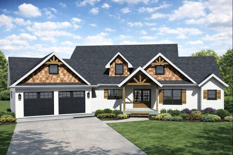 Modern two-story house with white siding, black garage doors, and wooden accents on the gables, surrounded by a well-manicured lawn and colorful bushes under a partly cloudy sky.