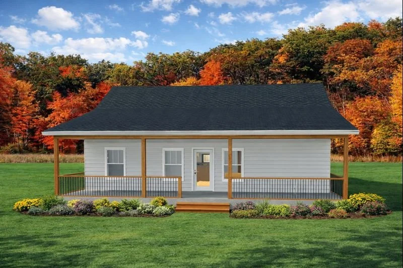 A house with white siding, a black roof, and a front porch with wooden railing and steps, set against a backdrop of trees with autumn-colored leaves and a green lawn.