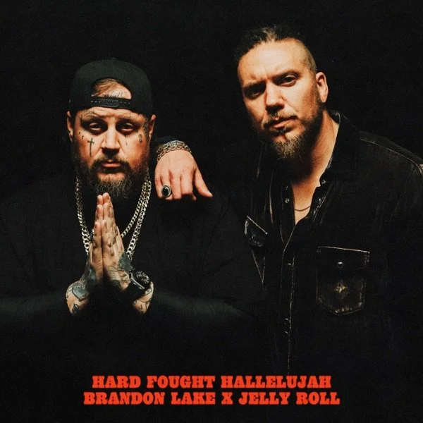 Two men with serious expressions posing against a black background. The man on the left has tattoos, wears a black cap backwards, multiple chains, and has his hands pressed together in a prayer gesture. The man on the right has a beard, tattoos on his neck, and is wearing a black jacket. Bold red text at the bottom reads "HARD FOUGHT HALLELUJAH BRANDON LAKE X JELLY ROLL."